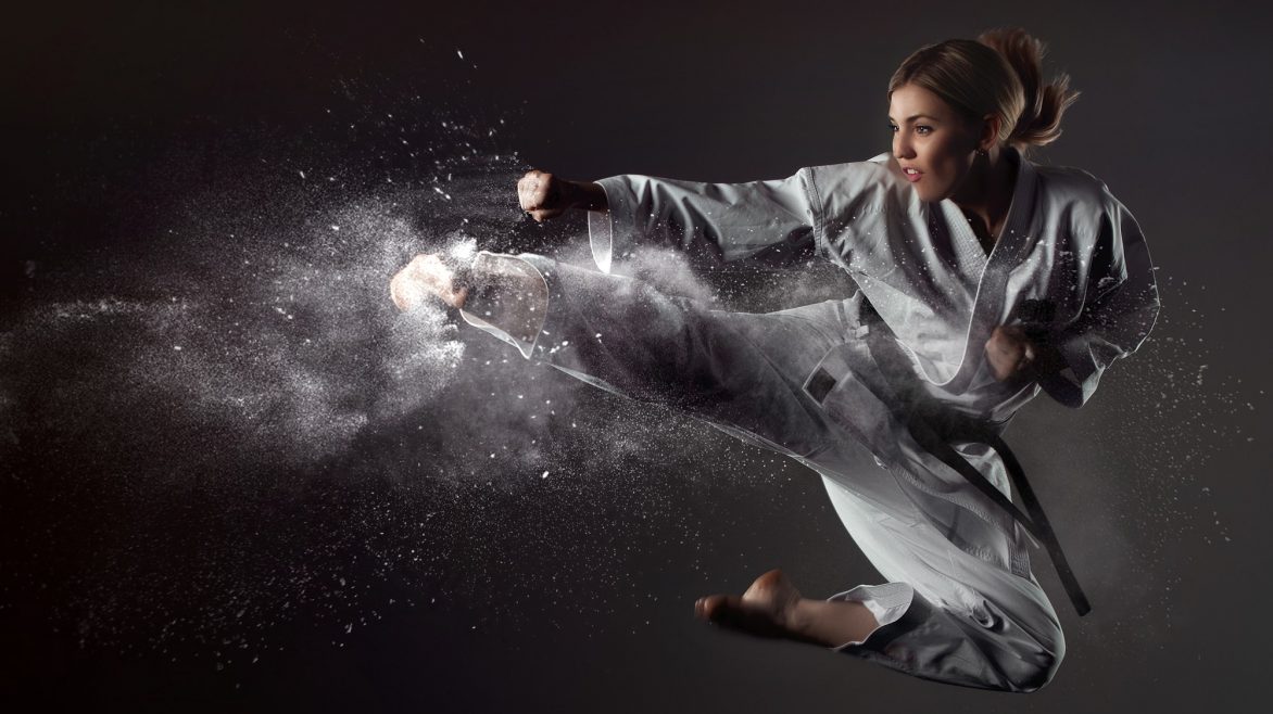 Karate girl bounces and makes a kick